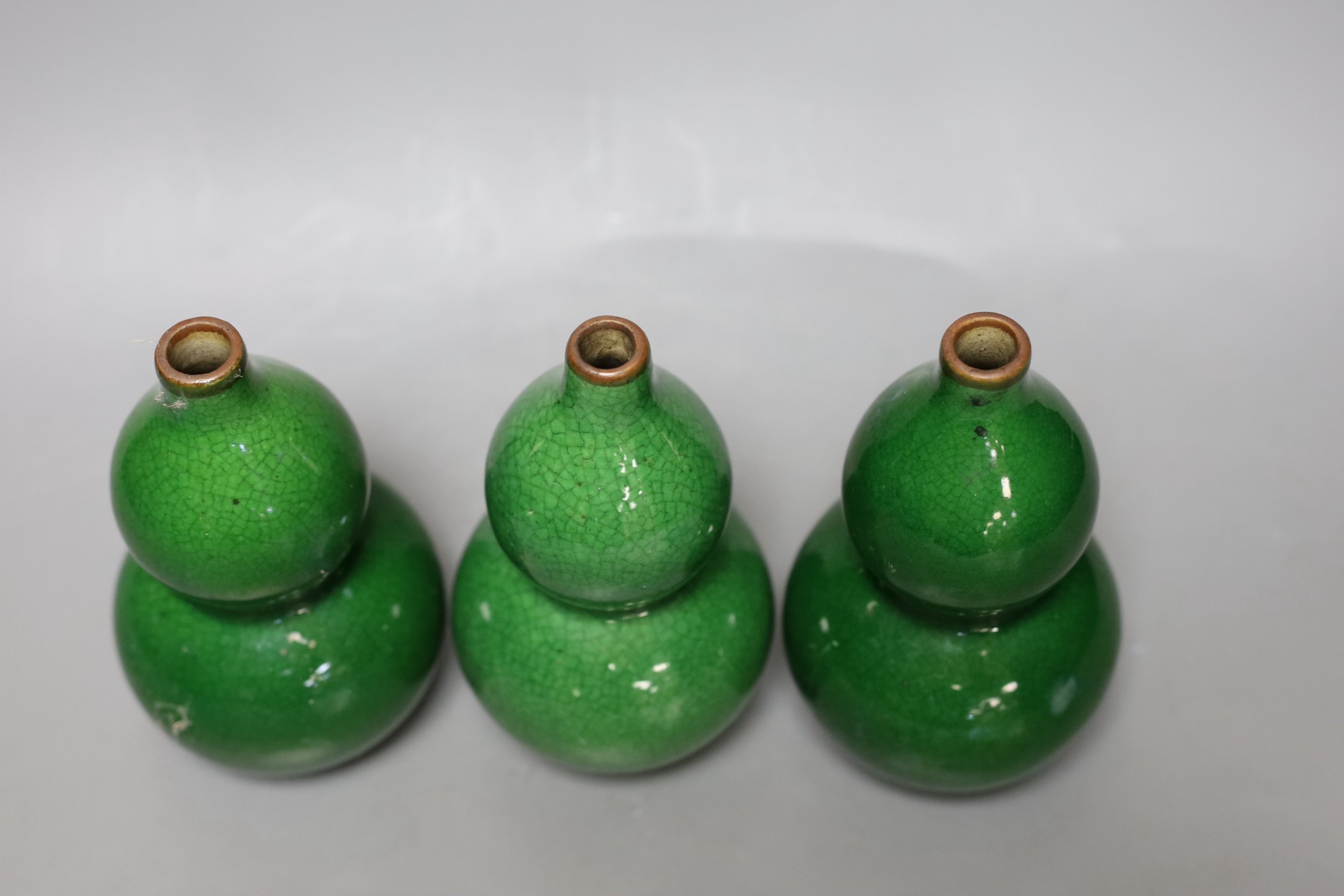 Three Chinese green crackle glazed double gourd vases, 15cm